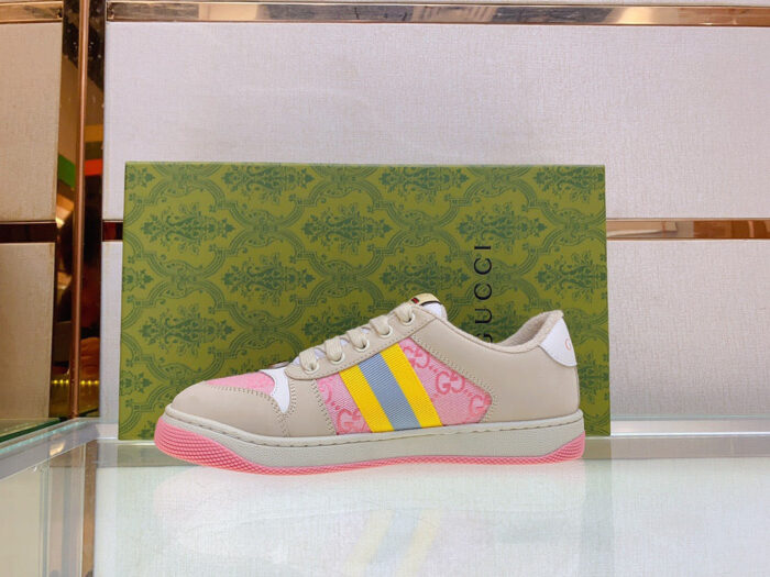 Scarpa Gucci colorata con dettagli vivaci su sfondo verde elegante, stile moderno e di lusso.
