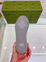 Sole di scarpa di lusso con dettagli eleganti, sfondo verde e confezione di marca raffinata