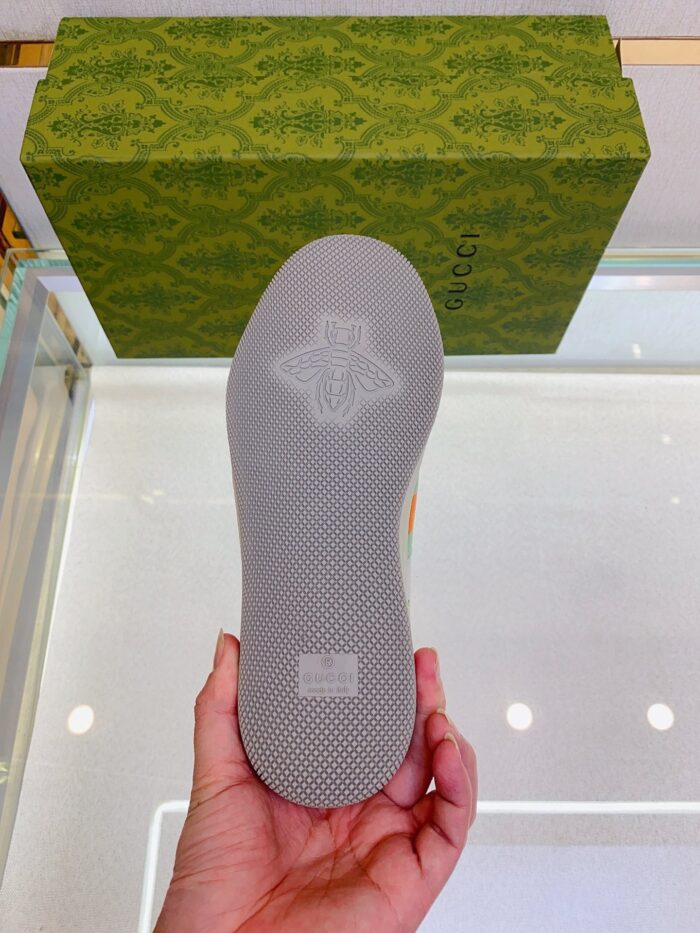 Sole di scarpa di lusso con dettagli eleganti, sfondo verde e confezione di marca raffinata