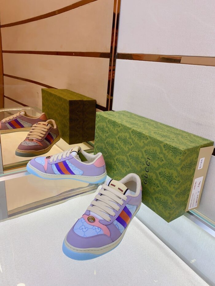Sneaker di lusso colorate su superficie riflettente con box verde elegante, stile moderno e sofisticato.