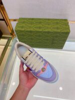 Scarpa sneaker colorata con design raffinato in negozio di lusso, dettaglio logo e materiali premium.