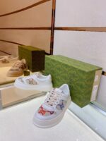 Sneakers di lusso con dettagli colorati, packaging elegante e stile contemporaneo su superficie riflettente.