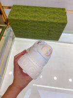 Sneaker Gucci bianca di lusso con scatola elegante, mostrata tra le mani di una persona alla moda.