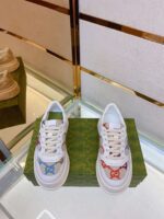 Sneaker bianche con dettagli colorati display in ambiente moderno e raffinato.