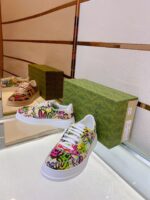 Sneaker artistica colorata su superficie riflettente con scatola verde, stile moderno e originale.