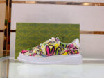 Sneaker multicolore moderna con suola spessa e packaging elegante verde lucido.