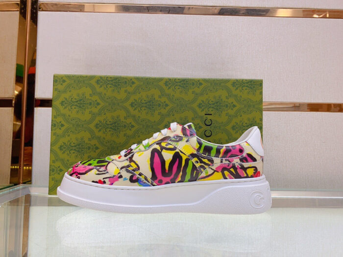 Sneaker multicolore moderna con suola spessa e packaging elegante verde lucido.