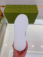 Scarpa Gucci con suola di lusso e packaging verde elegante, stile moderno e raffinato.