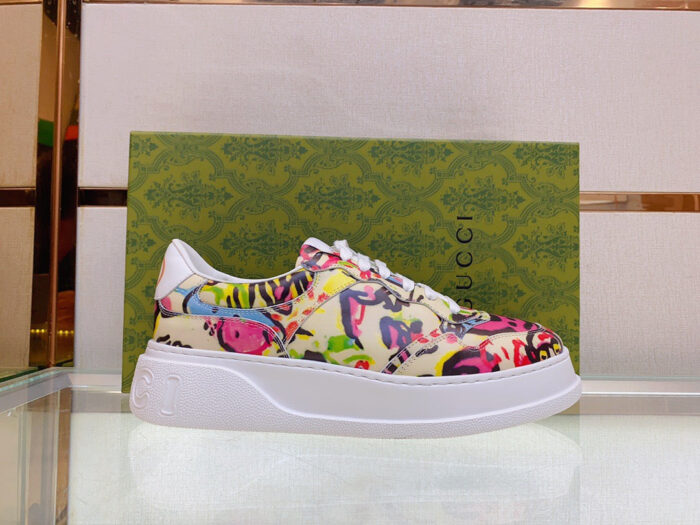 Sneaker Gucci floreale colorata con suola chunky, esposta su vetrina elegante.