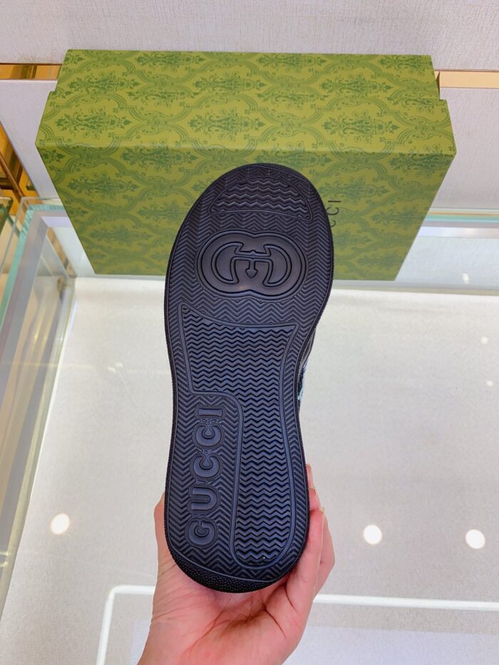 Sola di scarpa Gucci, dettaglio di lusso su sfondo elegante e riflettente.
