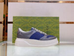 Scarpe sneakers di lusso in pelle con dettagli moderni su superficie di vetro riflettente.