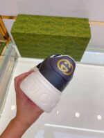 Sneaker Gucci stile moderno con logo dorato, in elegante packaging di lusso.