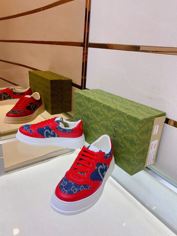 Scarpe sportive di lusso rosso e blu in esposizione moderna con dettagli eleganti.