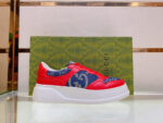 Sneaker Gucci rossa e blu con logo, su scatola elegante di lusso.