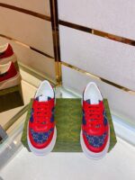Sneakers di lusso rosso e blu su piattaforma verde, stile sportivo e sofisticato.