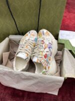 Sneakers colorati con disegni cartoon in scatola, stile giocoso e creativo.