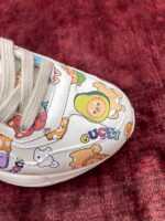 Sneaker colorata con personaggi cartoon divertenti, stile giovane e design creativo.