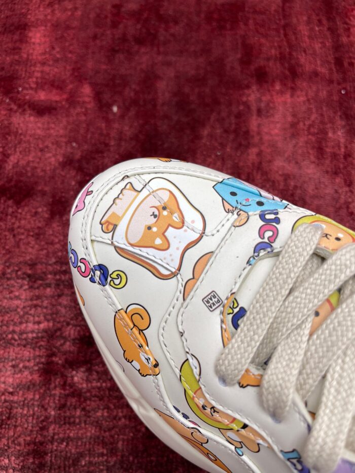 Sneaker bianca con illustrazioni divertenti e colori vivaci su fondo rosso morbido.