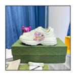 Sneaker bianca con grafica divertente su scatola verde elegante, stile moderno e casual.