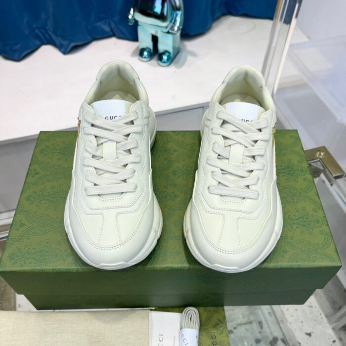 Sneakers da uomo bianche di lusso su scatola verde vibrante, stile moderno e raffinato.