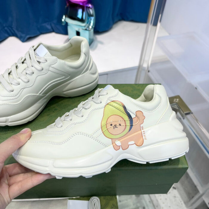 Sneakers bianche con grafica divertente, stile giovane e suola chunky in un negozio moderno.