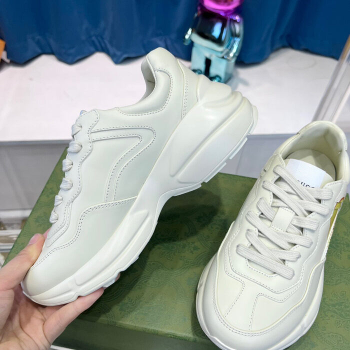 Sneakers bianche moderne, stile casual, comfort, design elegante su superficie verde con dettaglio giocoso.