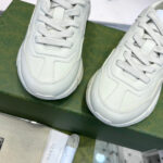 Sneakers di lusso in pelle bianche su scatola verde, stile elegante e moderno.