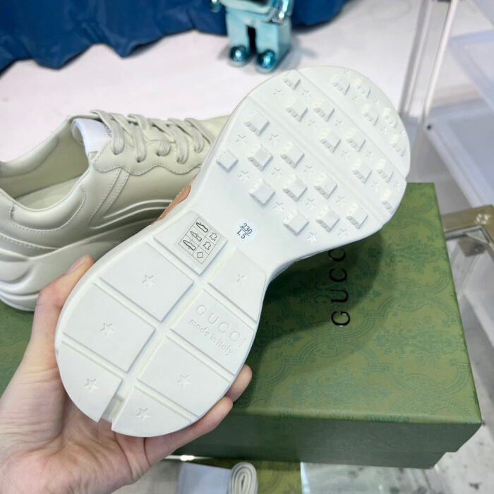 Sole di sneaker Gucci bianca, elegante e dettagliata, con confezione di lusso in sfondo.