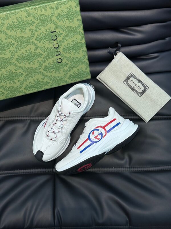 Sneakers di lusso Gucci con scatola e accessori esclusivi su sfondo elegante.