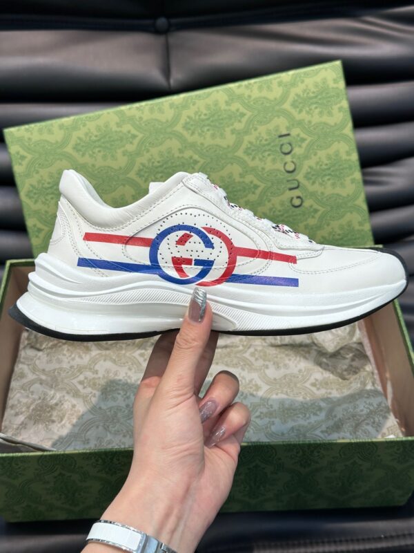 Sneaker Gucci bianca con dettagli colorati e confezione elegante, rappresenta lusso e stile moderno.