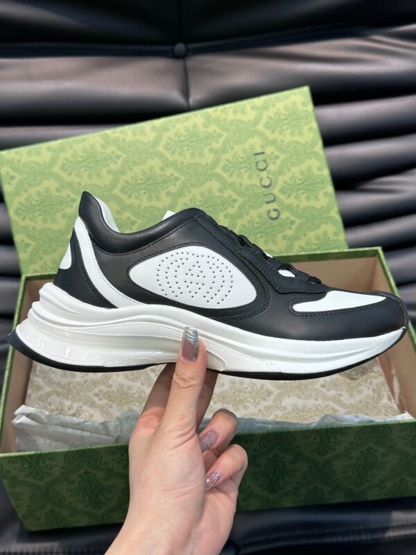Sneaker di lusso nero e bianco in scatola elegante, stile moderno e comfort raffinato.
