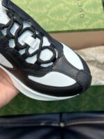 Sneaker di lusso in nero e bianco con dettagli innovativi e design moderno.