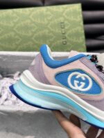 Sneaker Gucci moderna con logo blu, dettagli eleganti e design di alta qualità.