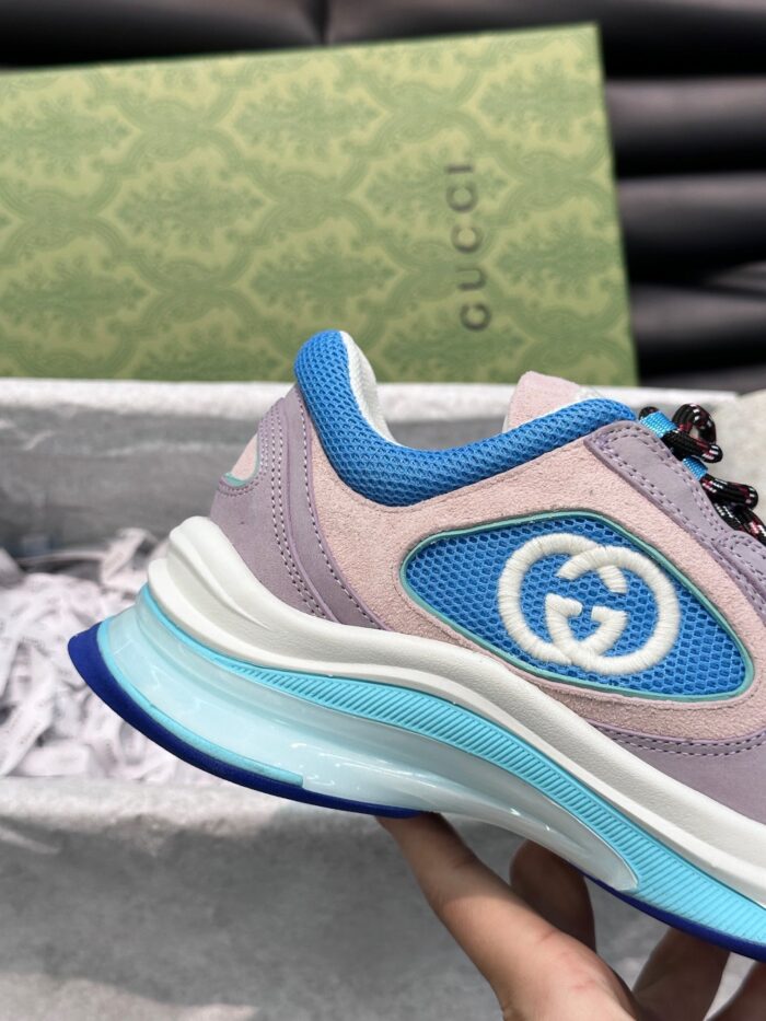Sneaker Gucci moderna con logo blu, dettagli eleganti e design di alta qualità.