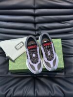 Sneakers di lusso con logo rosso, confezione elegante e design moderno su superficie nera testurizzata.