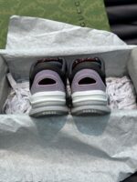 Sneaker nere di lusso con dettagli grigi e viola, in confezione elegante e alla moda.