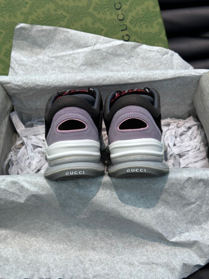 Sneaker nere di lusso con dettagli grigi e viola, in confezione elegante e alla moda.