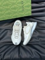 Sneakers Gucci bianche di lusso con packaging elegante su sfondo in pelle raffinata.