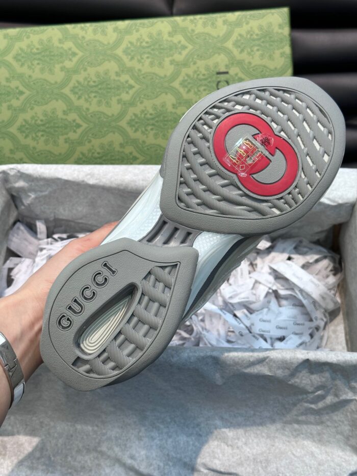 Suola elegante Gucci con logo rosso, packaging di lusso e dettagli artigianali.
