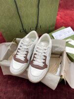 Sneakers di lusso Gucci bianche con dettagli marroni, in confezione elegante con borsa e documenti.