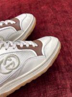 Sneakers bianche con logo, dettagli marroni e design moderno ideale per stile casual e fashion.