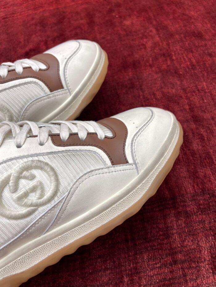 Sneakers bianche con logo, dettagli marroni e design moderno ideale per stile casual e fashion.