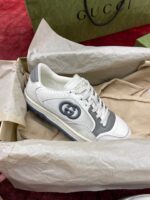 Sneaker Gucci bianca e grigia in elegante confezione di lusso con logo iconico.