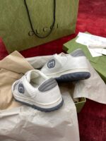 Scarpe Gucci di lusso, shopping bag, scontrino e dettagli eleganti su sfondo rosso raffinato.