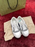 Sneaker Gucci eleganti su sfondo rosso con shopping bag, stile moderno e di lusso.