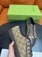 Scarpe di lusso con logo G, in pelle marrone, su tavolo nero con scatola verde.