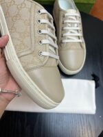 Sneakers beige di lusso con logo elegante e dettagli in materiale lucido, perfette per ogni occasione.