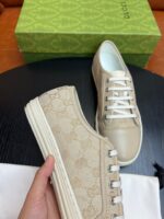 Sneakers Gucci beige con logo, suola bianca, dettagli eleganti e stile moderno di lusso.