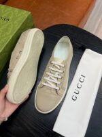 Sneakers Gucci beige in suede con dust bag di lusso e packaging elegante a sfondo scuro