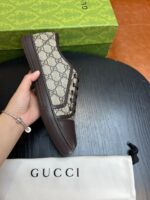 Sneaker di lusso monogrammata con scatola verde e dust bag elegante.